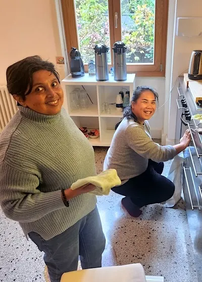 Cherishing Day – Zentrumswertschaetzungs-Tag-ma-ph Zwei weibliche Personen helfen mit Reinigungsarbeiten in der Küche mit, ein buddhistisches Zentrum zu pflegen.